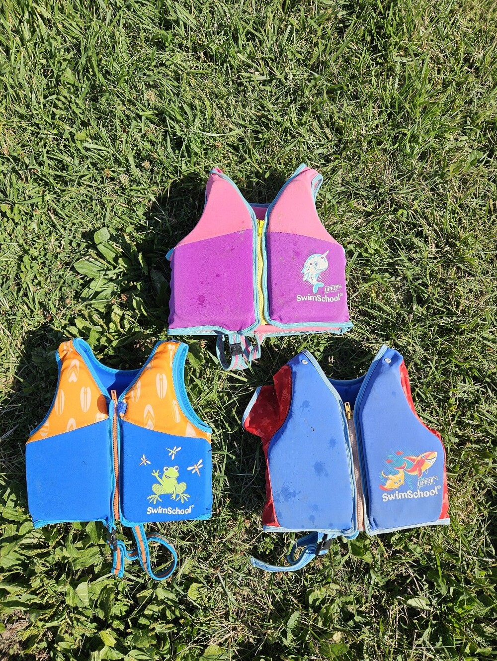 SwimSchool kids life jackets in blue/orange with white chevron pattern and green